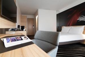 a bedroom with a bed and a couch and a table at Novotel Amsterdam City in Amsterdam