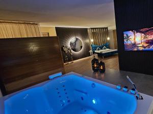 una grande vasca blu in una camera con TV di Privat-Spa mit Whirlpool und Sauna in Sursee a Sursee