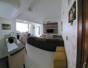 a living room with a couch and a tv at Hotel Globo in Cianorte