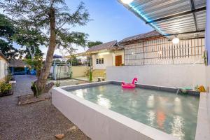 a swimming pool with a pink swan in a backyard at สตาร์ไลท์ พูลวิลล่า ชะอำ หัวหิน in Ban Huai Sai Tai