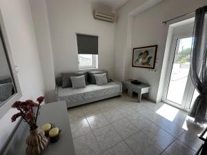 a living room with a couch and a table at Nick & Alex, Beautiful Village Apartment in Míthoi