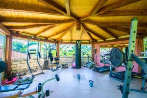 a gym with a large wooden ceiling and lots of exercise equipment at Villaggio Costa Real in Capo Vaticano