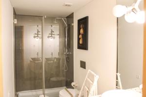 a bathroom with a shower with a glass door at Urban Master in Aveiro