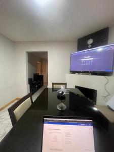 a laptop sitting on a table with a tv on the wall at Casa Moderna San Rafael - 2 DORMITORIOS Y SALA MULTIMEDIA CON YOUTUBE in San Rafael