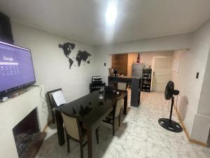 a living room with a table and a tv on a wall at Casa Moderna San Rafael - 2 DORMITORIOS Y SALA MULTIMEDIA CON YOUTUBE in San Rafael