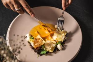 eine Person, die ein Dessert mit Gabel und Messer isst. in der Unterkunft Panoramahotel Watles in Mals im Vinschgau
