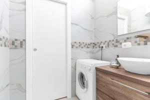 a white bathroom with a washing machine and a sink at Appartamento x4-self check-in-M2 Famagosta-AC in Milan