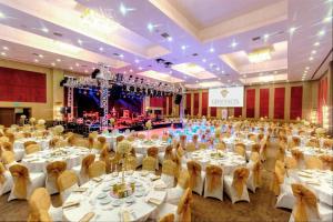 um salão de banquetes com mesas e cadeiras e um palco em Grannos Thermal Hotel & Convention Center em Haymana