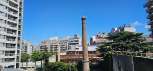 a tall building with a smoke stack in a city at PALERMO APART in Buenos Aires