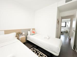dwa łóżka w pokoju z białymi prześcieradłami w obiekcie MyFlats Luxury Arenales w mieście Arenales del Sol +37 zdjęć