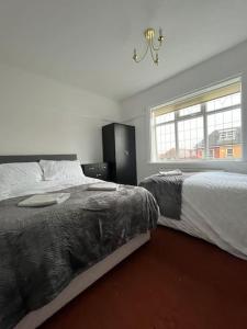 a bedroom with two beds and a window at West Street House-Furnished Let in Hoyland Nether