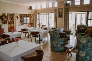 a restaurant with tables and chairs in a room at White Linen Guesthouse in Tierpoort
