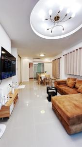 een woonkamer met een bank en een tafel bij Airport House BKK in Ban Khlong Lat Bua Khao