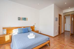 una camera da letto con un grande letto con lenzuola blu e cuscini blu di Villa Alvor ad Alvor Altre 13 foto