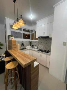 a kitchen with white cabinets and a wooden counter top at EMILIEZ PLACE in Baguio +32 photos