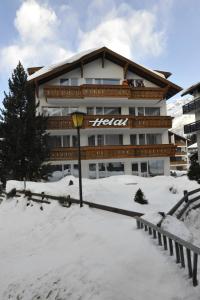un hôtel dans la neige devant un bâtiment dans l'établissement Heidi, à Saas-Fee