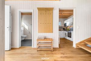 een keuken met witte muren en een houten vloer bij Ferienhaus Krabbenkaddy Olpenitz in Kappeln