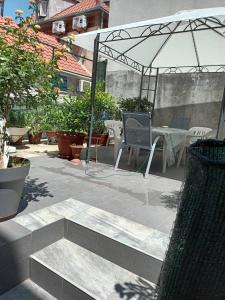 a patio with a table and chairs and an umbrella at Cozy Studio Apartments with Terrace Near Kaštela Promenade in Kaštela +2 photos