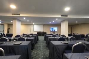 a conference room with tables and chairs and a screen at Hotel The Brand in Rome