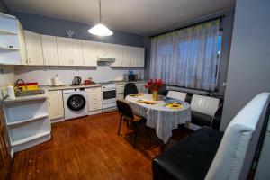 a small kitchen with a table with a vase of flowers on it at Apartament Suwałki Centrum Wesoła in Suwałki