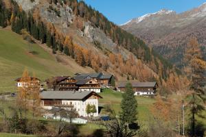 a group of buildings in a valley in the mountains at Giatla Hof der Alfenalm - Ferienwohnungen am Berg in Innervillgraten