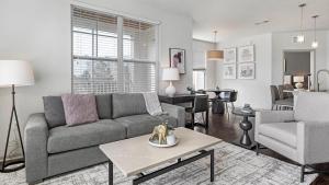a living room with a couch and a table at Landing at Perry Street Lofts - 2 Bedrooms in Petersburg in Petersburg
