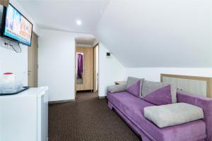 a living room with a purple couch and a tv at Casa Dinii in Constanţa +55 photos