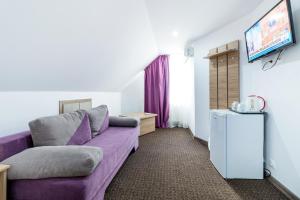 a living room with a purple couch and a tv at Casa Dinii in Constanţa