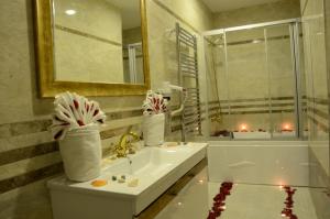 a bathroom with a sink and a mirror and a tub at Gumus Palace Hotel in Istanbul