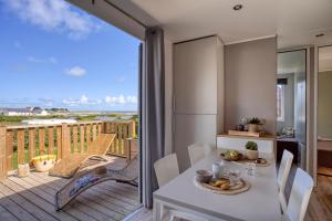 a kitchen and dining room with a balcony at Slow Village Breizh Légendes in Plounéour-Trez