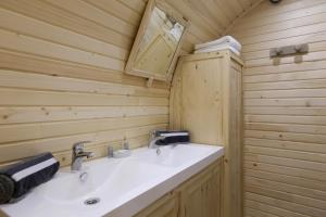 JanvryにあるDomaine De Margueriteの白い洗面台と木製の壁が備わるバスルーム