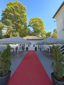 una pasarela de moqueta roja con sombrillas blancas en VILLA BOWDY, en Niederzier