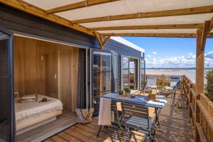 a room with a bed and a table on a deck at Slow Village Breizh Légendes in Plounéour-Trez