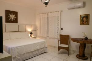 Olho D’Água do CasadoにあるRancho Império do Cajúのベッドとテーブルと椅子のある寝室