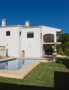 a white house with a swimming pool in front of it at La Renda Mediterranean Villa - Beach, Jávea Port and amenities within walking distance in Jávea