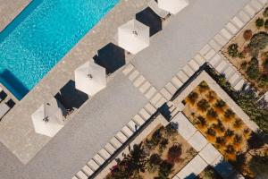 an overhead view of a pool with white tables and chairs at Archon Seaside Retreat in Plaka
