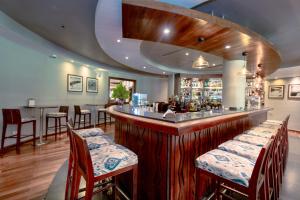 a bar in a restaurant with wooden tables and chairs at Dar es Salaam Serena Hotel in Dar es Salaam