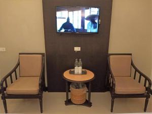 a room with a table and two chairs and a tv at Cathay Hotel in Betong