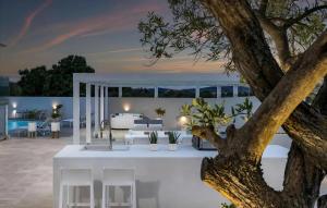 an outdoor patio with a white table and chairs and a tree at Lalic Gallery Villa in Bibinje