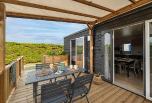 a patio with a table and chairs on a deck at Slow Village Breizh Légendes in Plounéour-Trez +66 photos