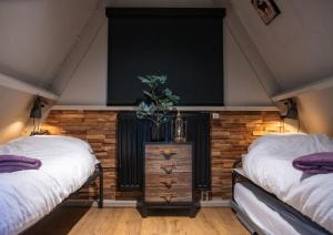 two twin beds in a room with wooden walls at Boshuisje Viva l'Ardenne - Chalet 122 in Durbuy +67 photos