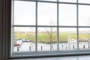 a window view of a marina with boats in the water at Hotel De Heeren in Veere