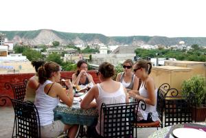 Un gruppo di donne sedute intorno a un tavolo su un tetto di Sneh Deep Guest House a Jaipur