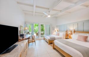 a bedroom with two beds and a flat screen tv at Islander Resort in Islamorada +31 photos