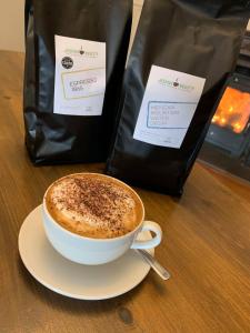 a cup of coffee sitting on a table next to a bag at The Corner House Hotel in Annan +24 photos