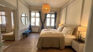 a bedroom with a bed and a couch and windows at The Admirals Apartments 1 & 2 in Copenhagen