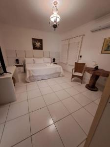 Olho D’Água do CasadoにあるRancho Império do Cajúの白い大きなベッドルーム(ベッド1台、テーブル付)