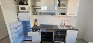 a small kitchen with white cabinets and a sink at Ilona Vanha Rauma in Rauma