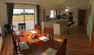 3 bedroom cottage near Kilrush & Doonbeg في غابات كيلرَش: مطبخ وغرفة طعام مع طاولة ومطبخ