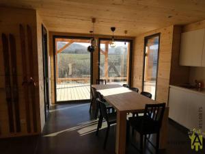 a dining room with a table and chairs and a large window at La Belle Etoile in Besse-et-Saint-Anastaise
